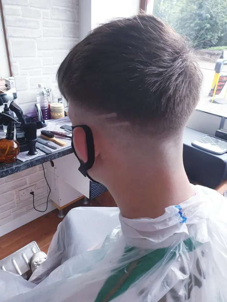 Side view of a freshly cut skin fade in the barber chair
